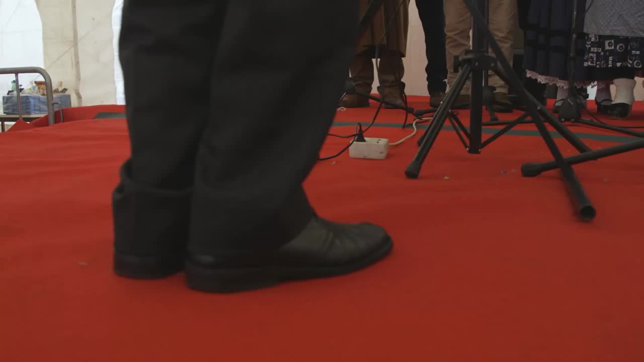 Fancy mans shoes on red carpet, man moving feet to rhythm. Detail shot
