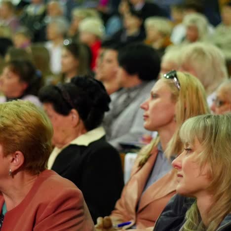crowd of people to sitting and listening in a large hall