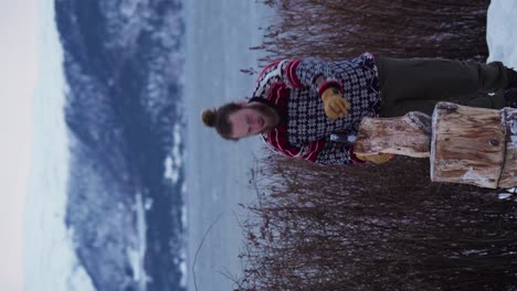 vertical - european man splitting wood using axe in winter