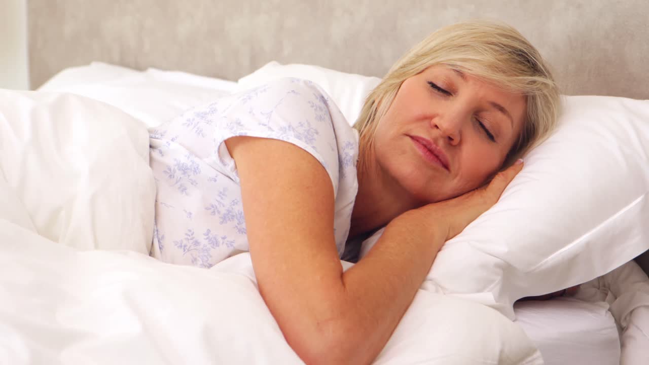 mujer tranquila durmiendo en la cama