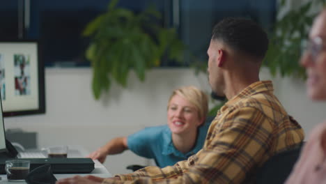 two business colleagues at desks in office working late on project together