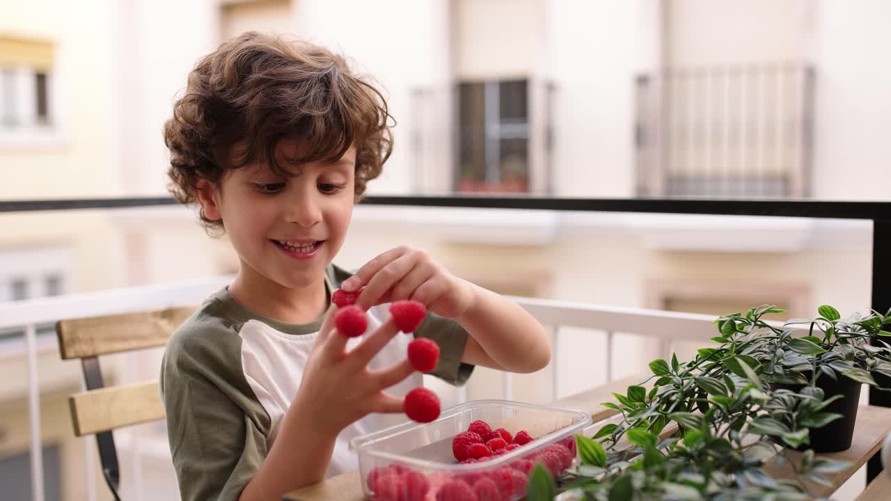 Cute boy touching and counting raspberry on fingers