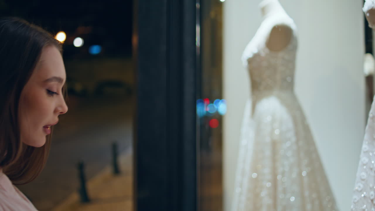 미래의 신부 드레스를 찾는 결혼식 가게 근처에 서있는 쇼케이스 저녁 클로즈업