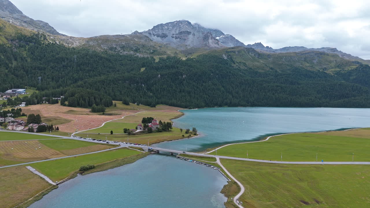 Serene lake near Silvaplana amidst majestic mountains and lush greenery