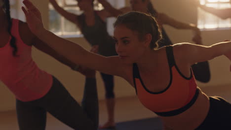 Junge,-Gesunde-Frau-Im-Yoga-Kurs,-Die-Die-„Lord-Of-The-Dance“-Pose-übt-Und-Bei-Sonnenaufgang-Mit-Einer-Gemischtrassigen-Gruppe-Von-Menschen-Im-Fitnessstudio-Trainiert