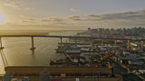 San-Diego-California-Antena-V95-Sitios-De-Construcción-De-Naves-Industriales-De-Sobrevuelo-Bajo-Con-Vista-Al-Puente-Coronado-Y-Al-Paisaje-Urbano-Del-Centro-En-El-Horizonte-Al-Atardecer---Filmado-Con-Cine-Mavic-3---Septiembre-De-2022