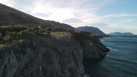 Hiker-walks-toward-the-edge-of-a-cliff-with-ocean-view-in-Spain