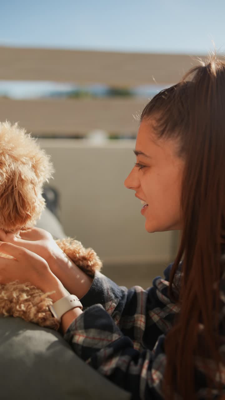 mujer jugando con su perro caniche afuera