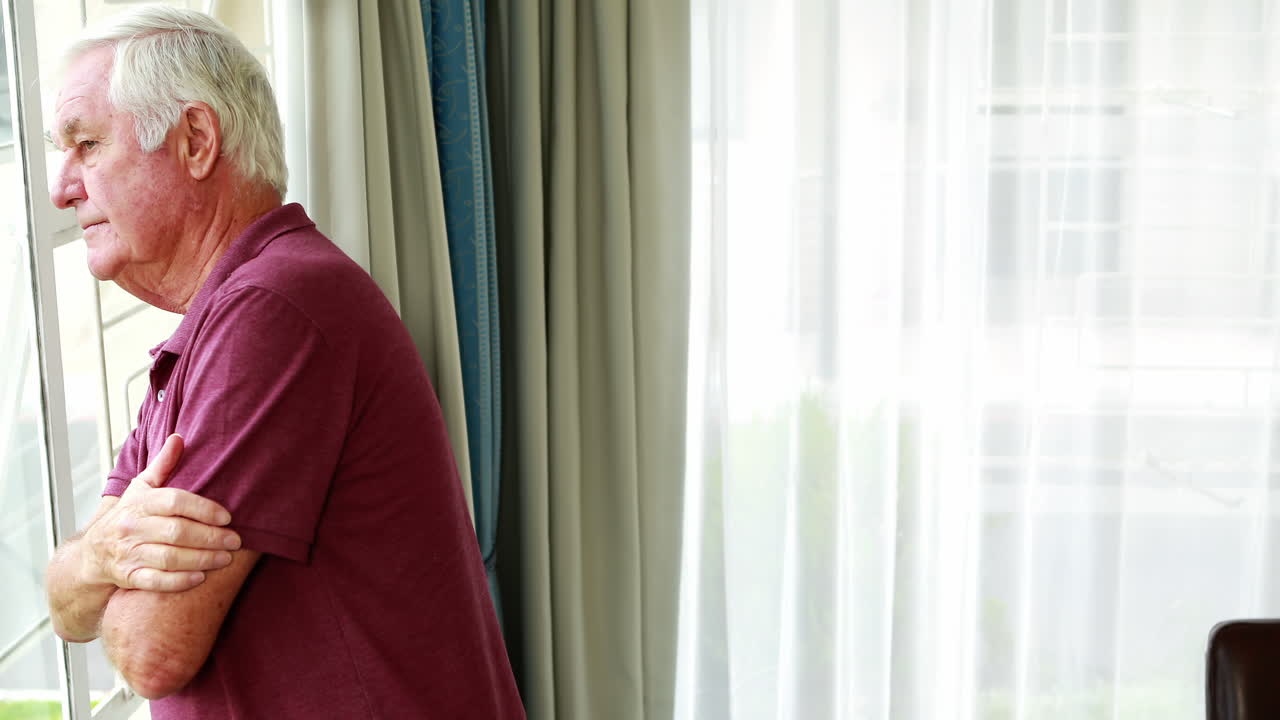 은퇴 한 사람 이 창문 을 통해 바라보면서 생각 하고 있다