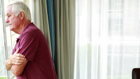 a retired person thinking while looking through the window
