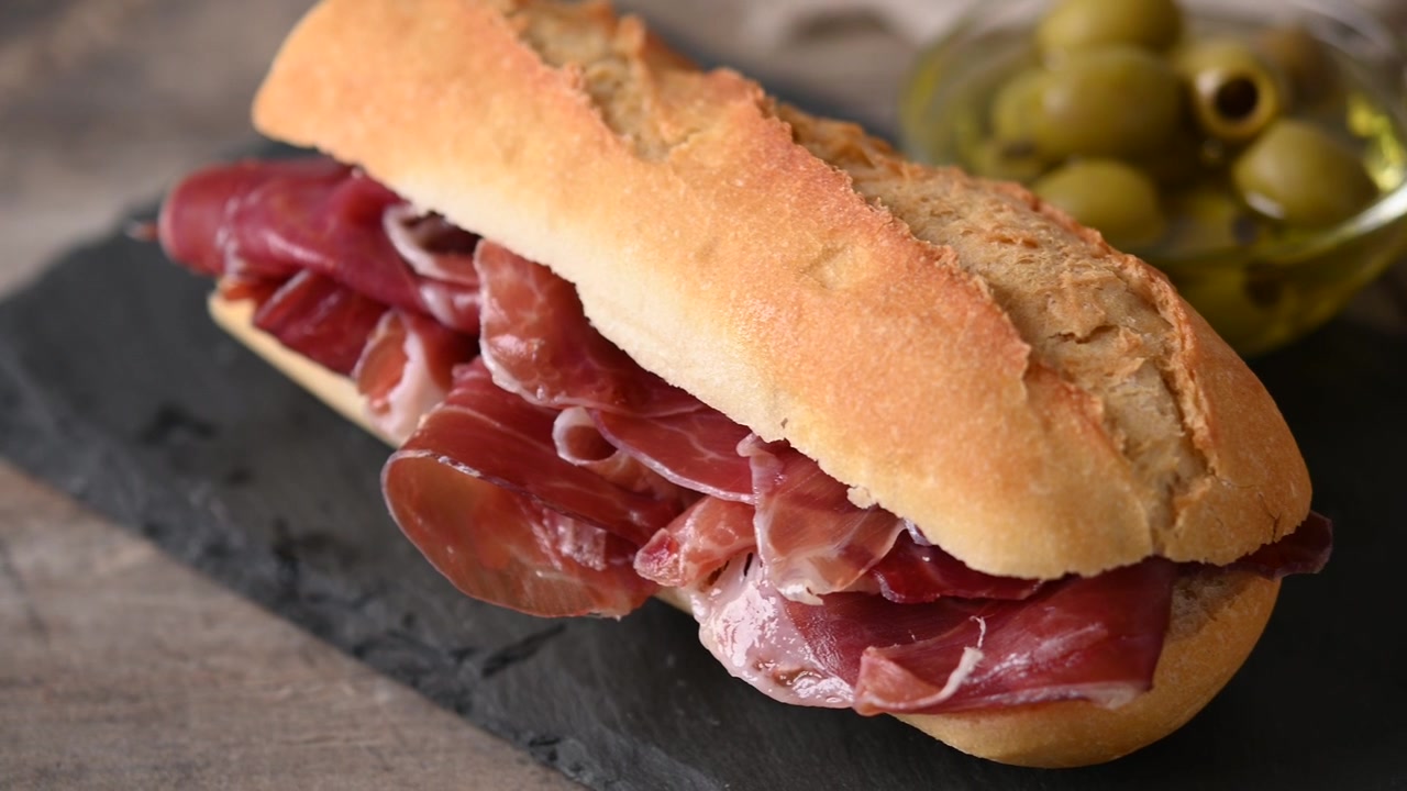 Panino con prosciutto serrano spagnolo su tavolo di legno. Bocadillo de jamón serrano spagnolo