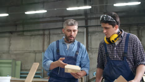 dos carpinteros caminando solos en el taller y discutiendo detalles de madera