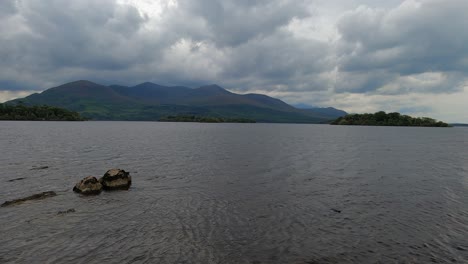 Low-angle-nature:-Heavy-overcast-cloud-over-mountain-lake-landscape