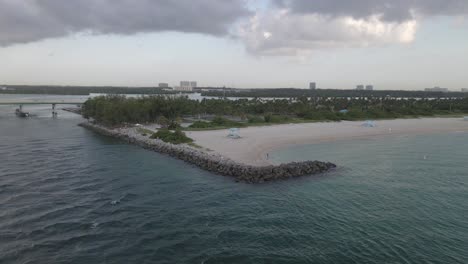 aerial: lone man tosses fish net from beach at haulover beach dog park
