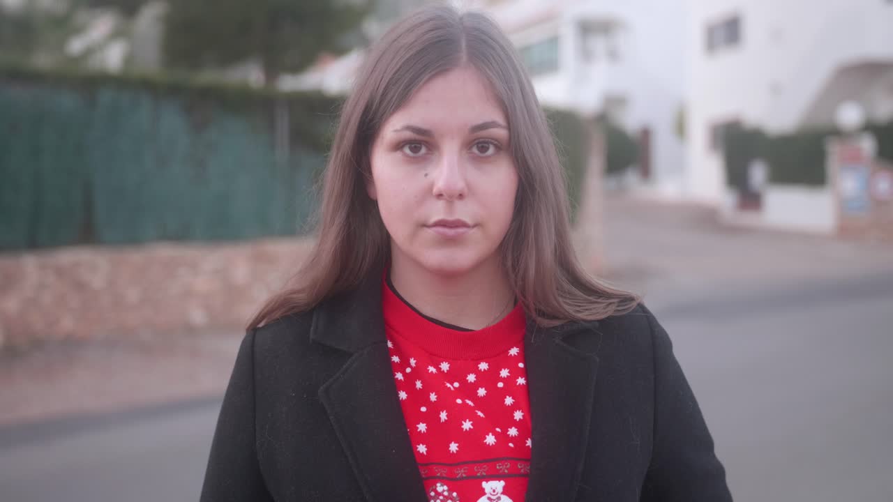 mujer joven quitándose la máscara quirúrgica en la calle