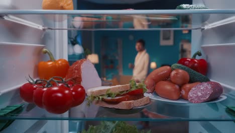 open refrigerator at night with food inside