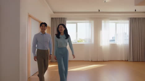 happy young asian couple in their new empty apartment