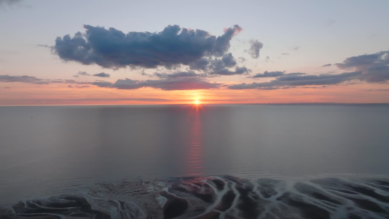 Sunset Over Calm Irish Sea With Reverse Camera Flight Revealing Tidal Sand Flats And Inlets. Golden Hour. Fleetwood, Lancashire, UK