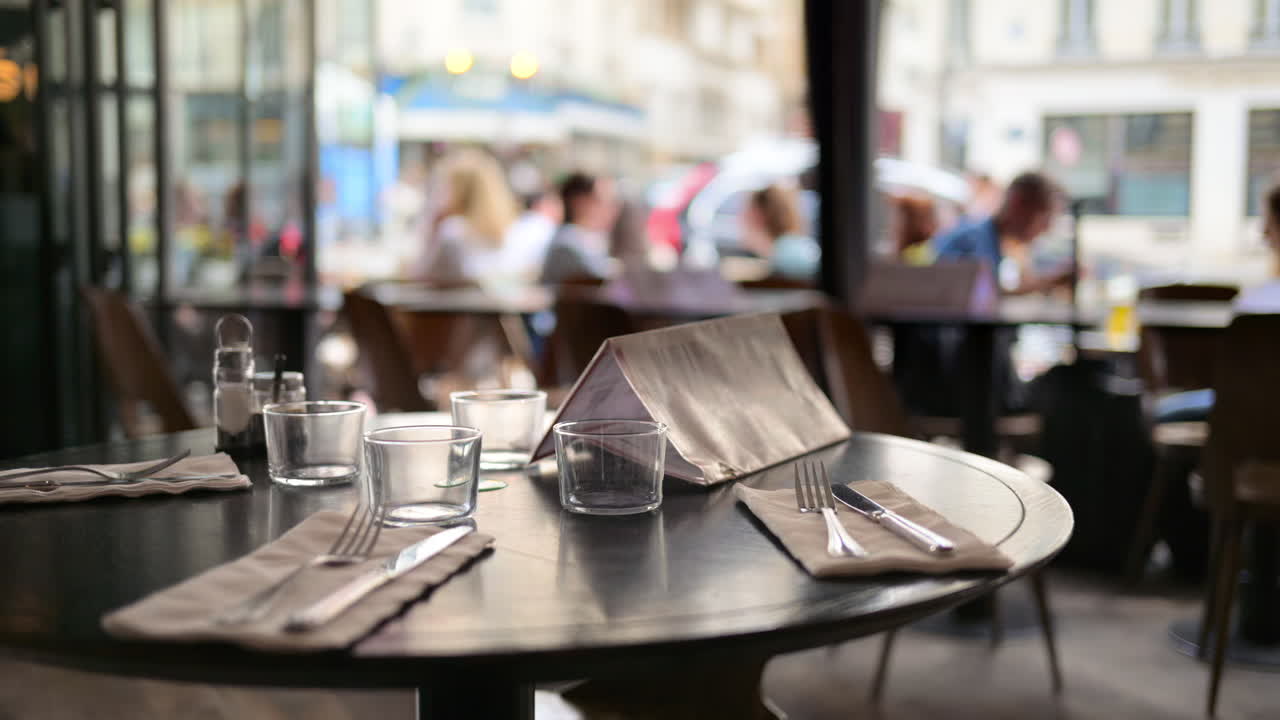 A table set at a restaurant in Paris, France, with blurred people eating on the background