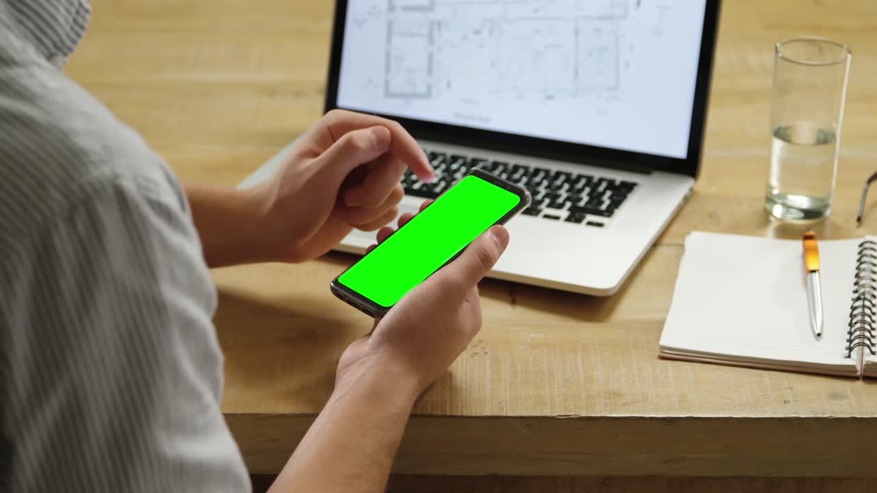 hombre usando teléfono inteligente y computadora portátil