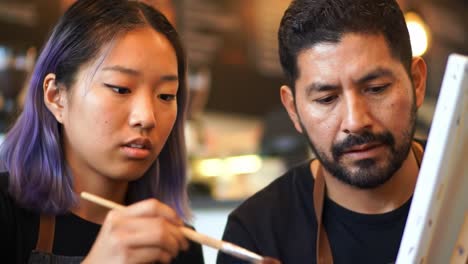 creative collaboration: a young artist and mentor captivated by their painting journey, sharing techniques and inspiration in a vibrant studio setting