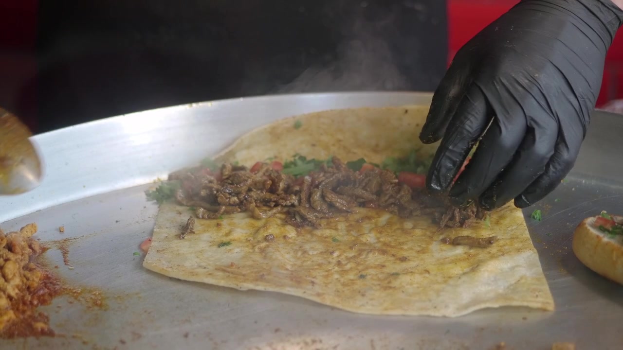 Chef préparant un wrap tantuni turc traditionnel dans une cuisine