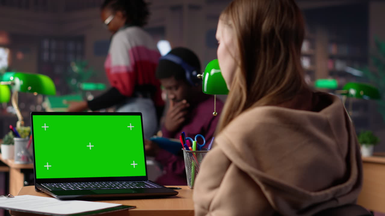 University scholar writes project ideas next to green screen on tablet