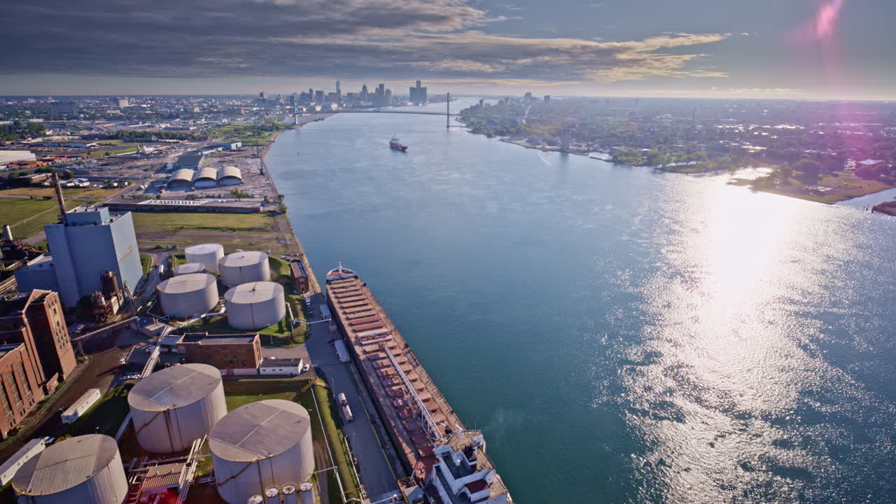 An overhead drone view travels the length of the Gordie Howe Bridge toward Detroit’s riverside factories