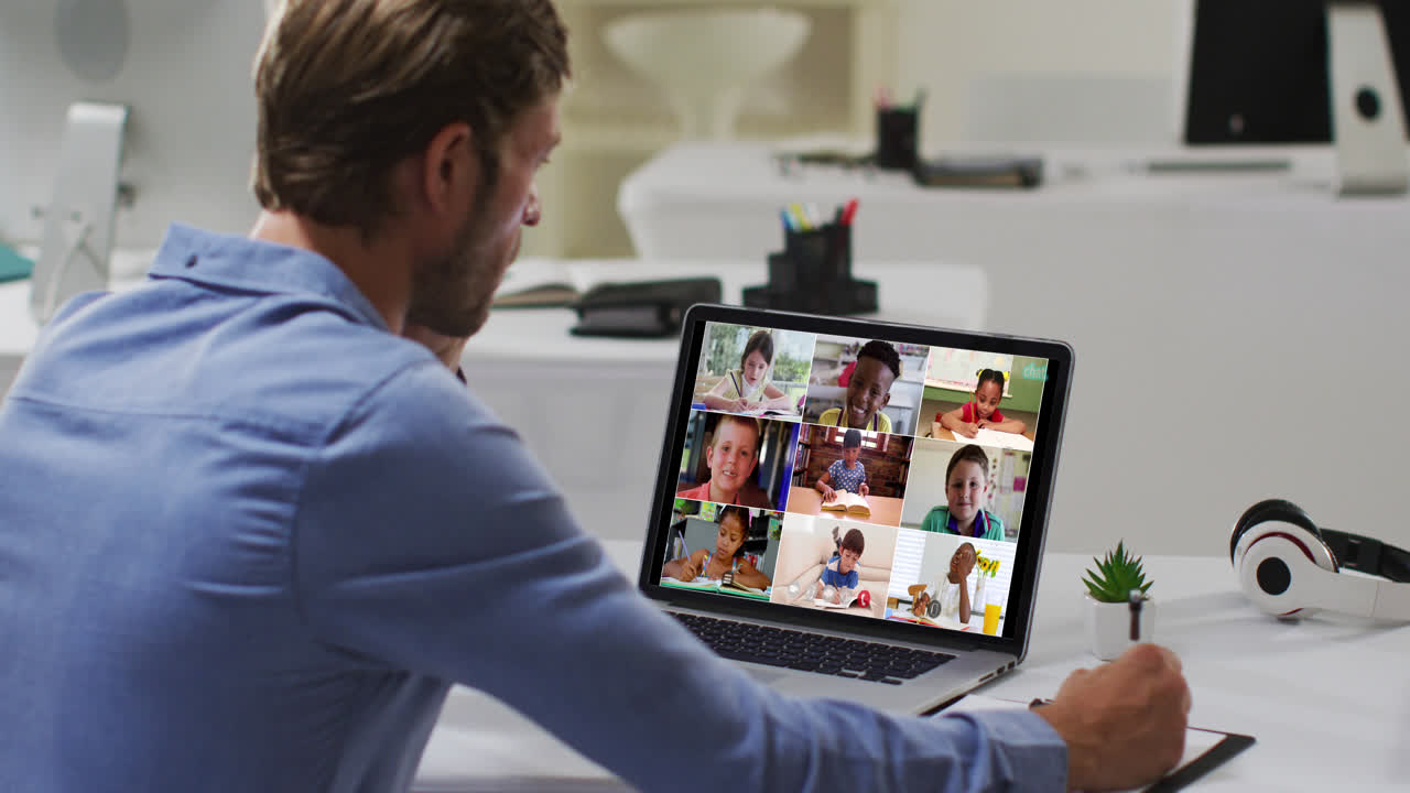 Caucasian male teacher using laptop on video call with school children