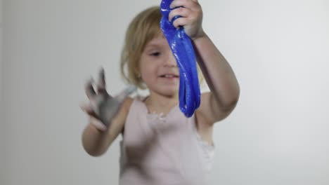 child having fun making slime. kid playing with hand made toy slime.