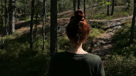 woman walking peacefully green forest path, calm walk in the nature, back view