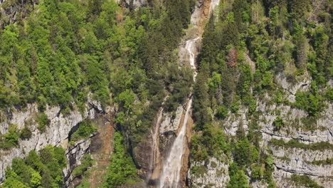 aerial view of seerenbachfälle waterfall cascading through a lush forested cliffside in amden, betlis, near walensee, switzerland