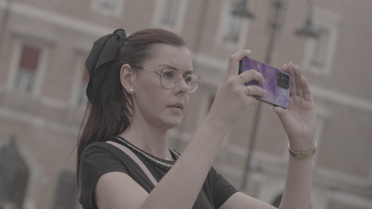 Krásná dívka s brýlemi fotí svým telefonem na dovolené v Itálii.