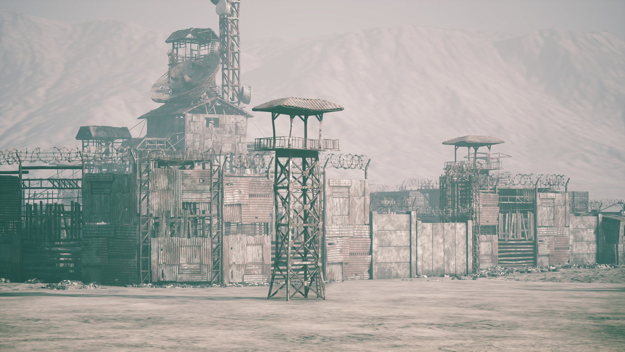 Abandoned military base in a desert landscape with watchtowers and rubble