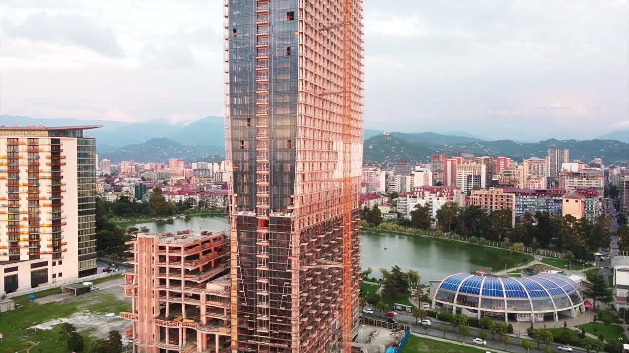 Aerial drone view of a building under construction in Batumi, Georgia. Modern buildings nearby, cityscpae on the background