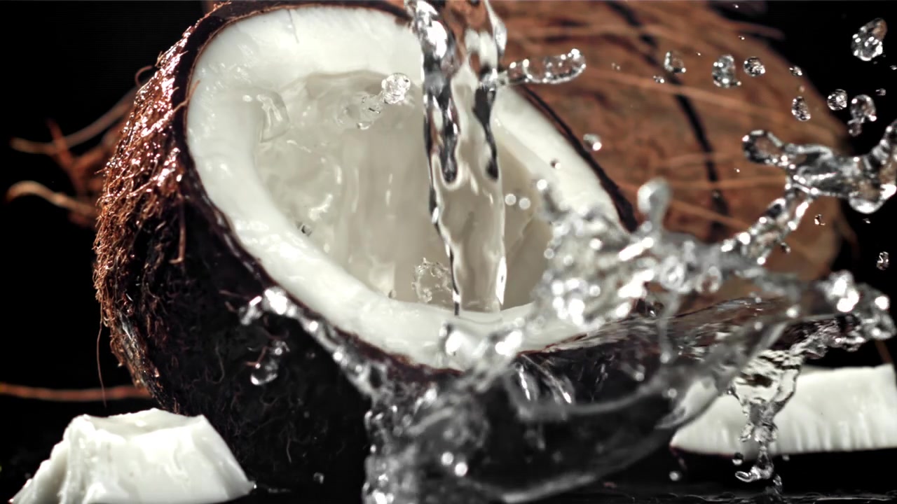 Slow Motion Water Pouring into a Fresh Cracked Coconut