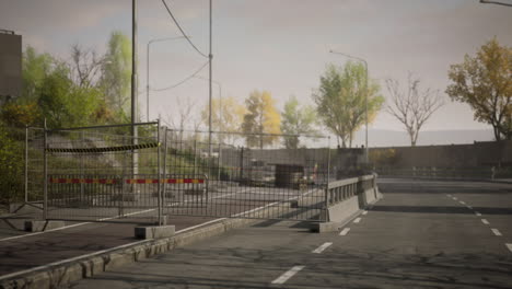 abandoned road with barriers and trees in the background during daytime