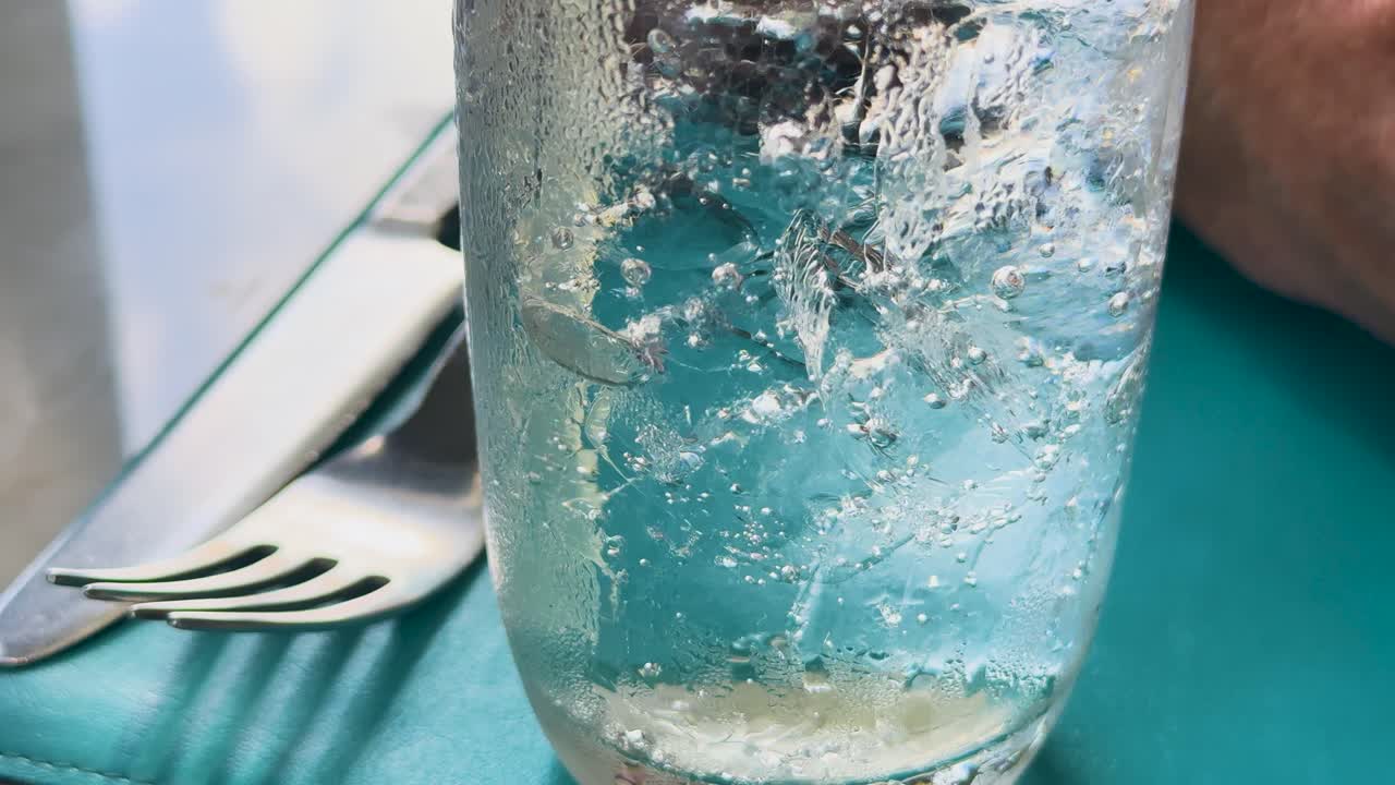식탁 위의 유리잔에서 상승하는 클럽 소다 거품의 클로즈업, 상쾌하고 활기찬 분위기를 만니다.