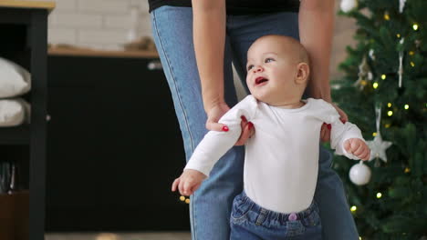 baby taking first steps with mother help