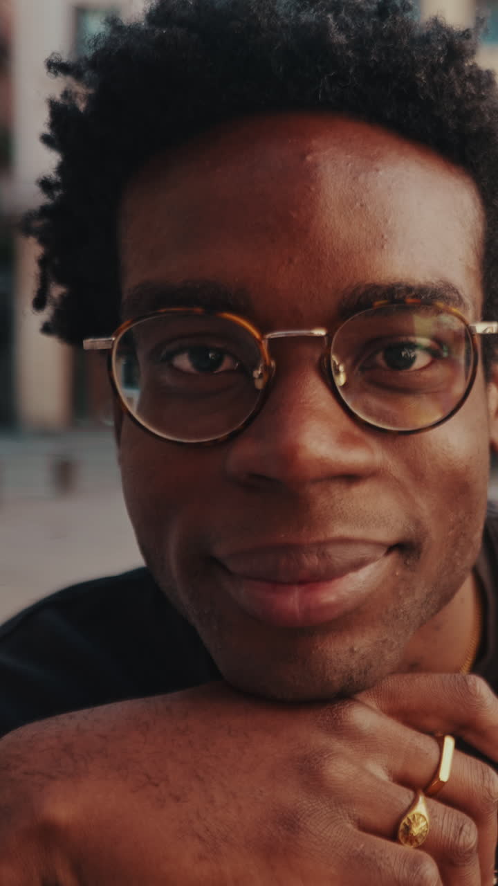 Close-up Portrait of a Young Black Man with Glasses Smiling