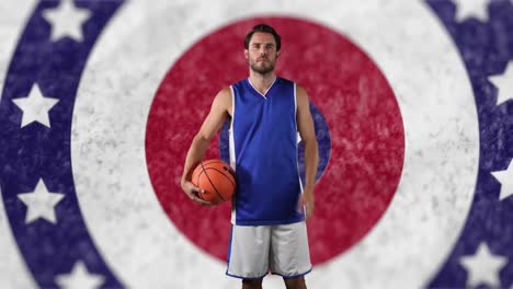 portrait of caucasian male basketball player holding a ball against stars on spinning circles