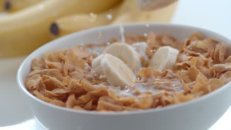 bananas falling into bowl of cereal in slow motion