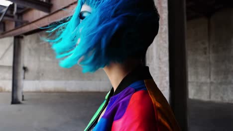 mujer con una chaqueta de colores vibrantes y cabello azul vibrante