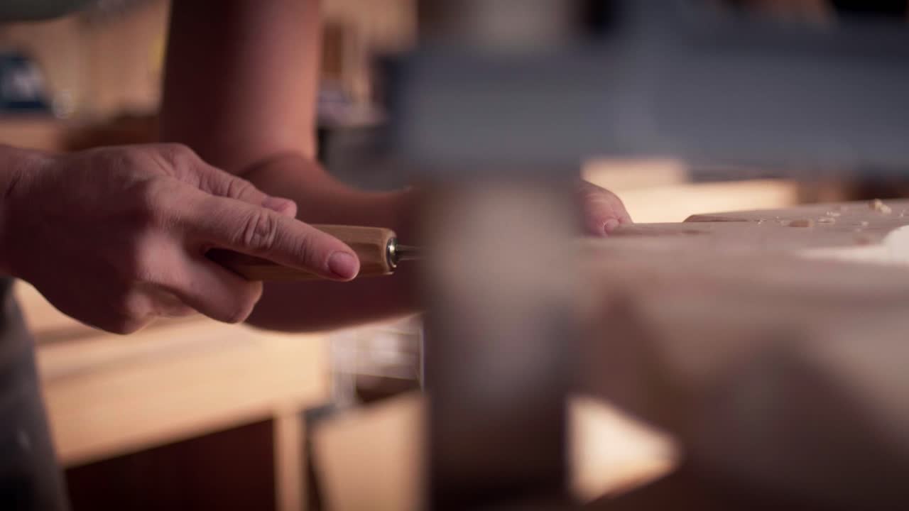 Woodworking professional smoothing the surface of a timber plank with a traditional hand plane tool. Medium shot, slow motion