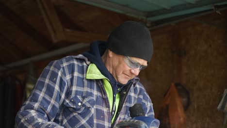 a male construction worker uses a table saw to cut a piece of wood and admires it after.