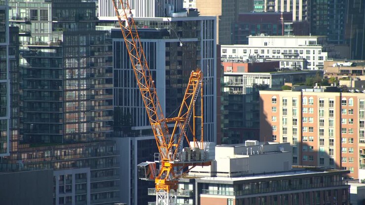 Industrial crane for construction in city close up, tall buildings in background