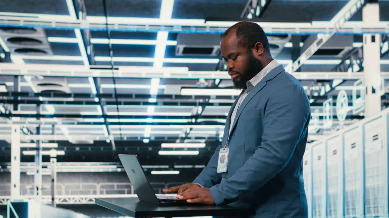 African American Man Working on Laptop in Data Center