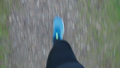 first-person-view: runner's feet jogging on a trail on a cloudy day