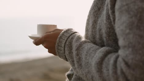 person enjoying coffee by the sea