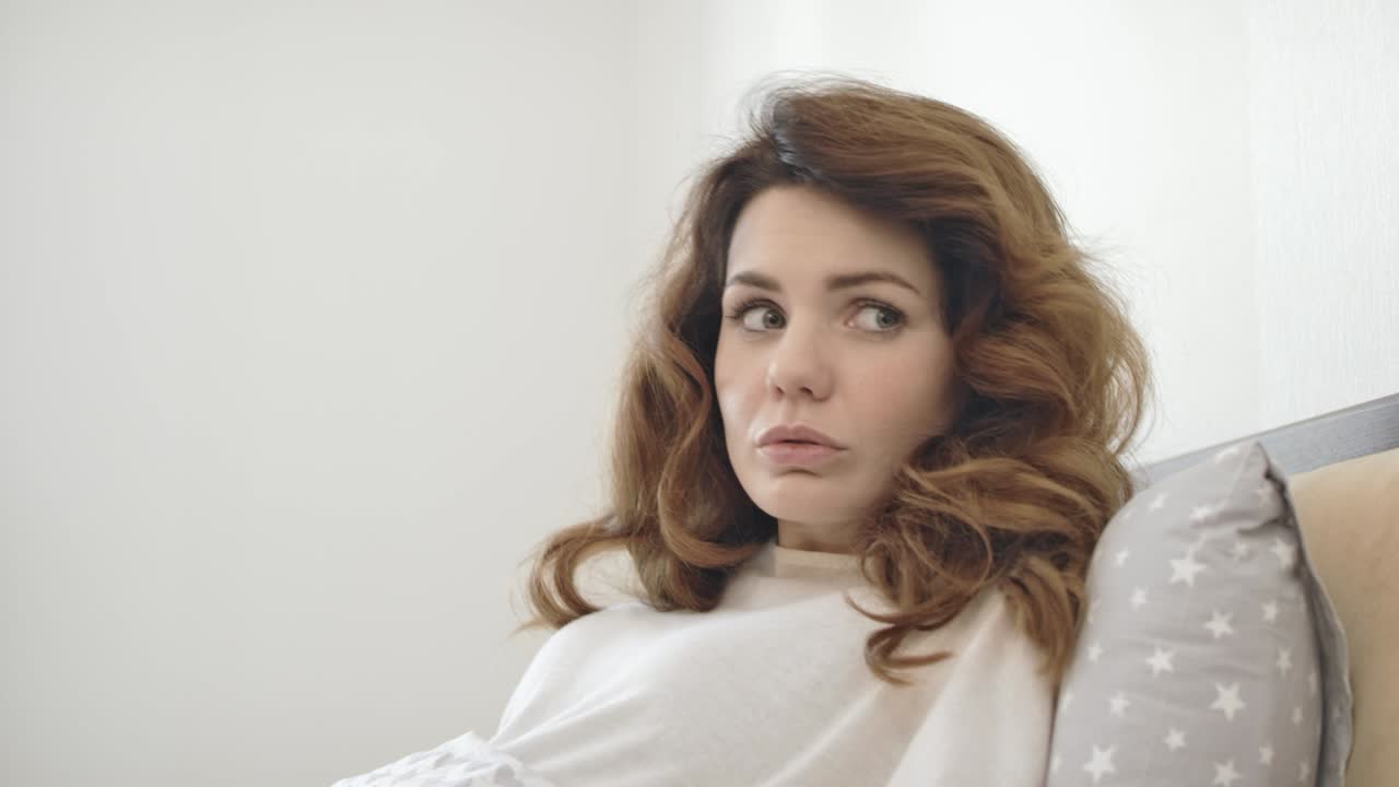 잠든 여자가 침대에서 갑자기 깨어난다. 악몽에서 회복하는 충격적인 여자가.